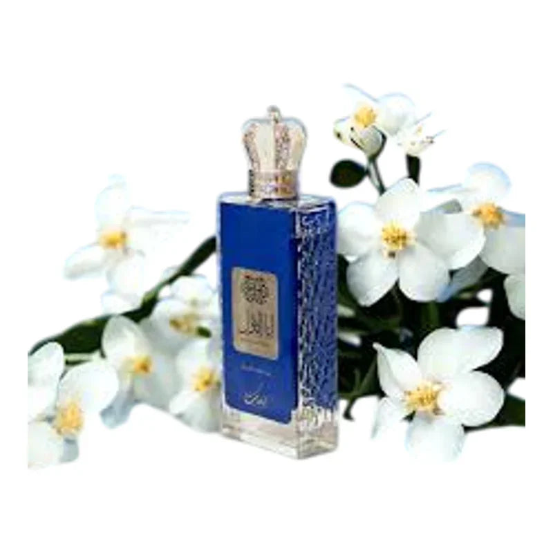 Flacon de parfum bleu avec bouchon couronne entouré de fleurs blanches délicates
