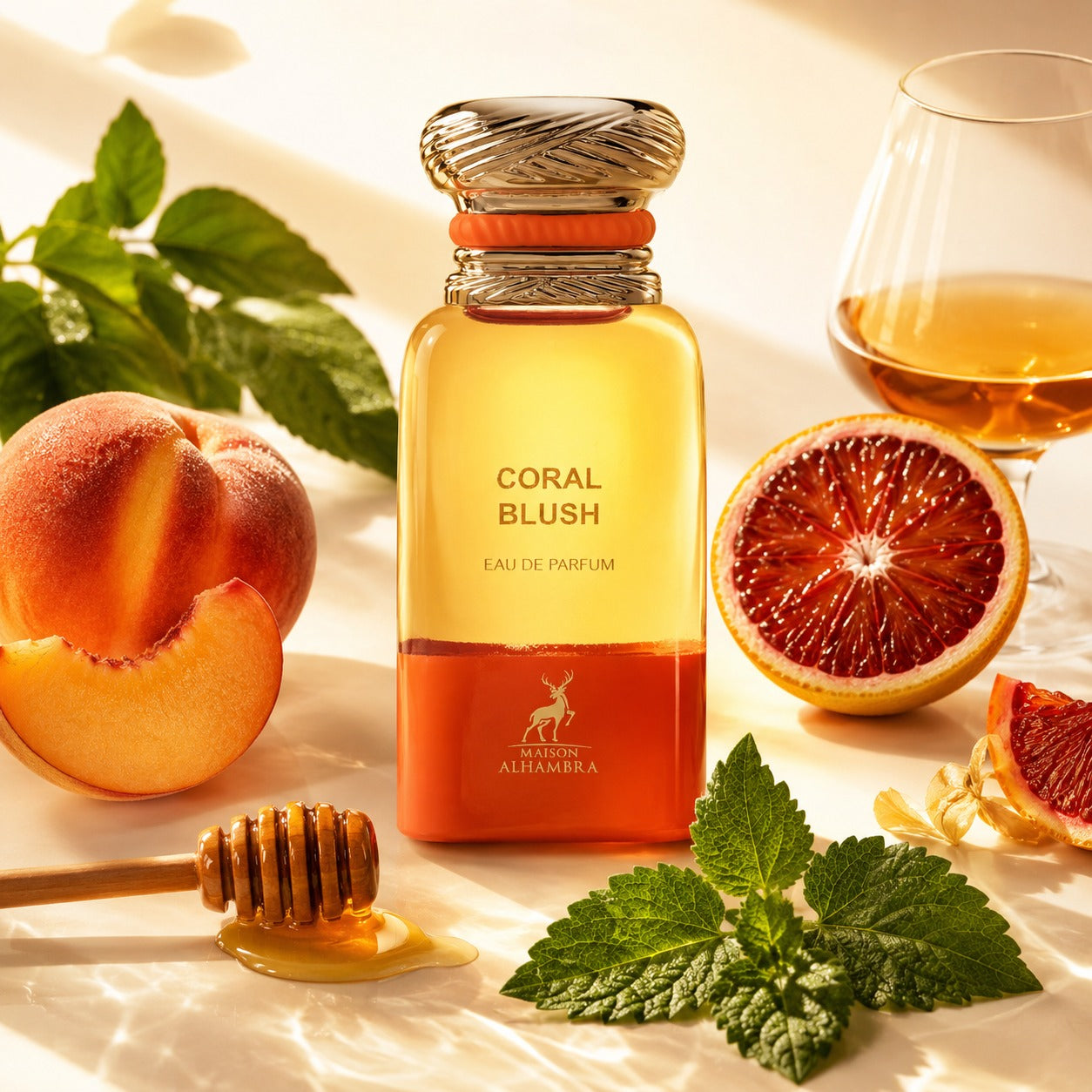ARVOLA_SHOWCASE — Coral Blush Maison Alhambra, photo artistique fond clair (pêche, feuilles vertes, orange sanguine, patchouli, miel, cognac)