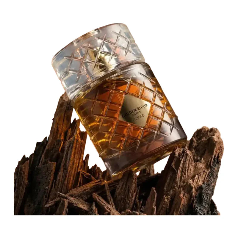 Flacon de parfum Golden Elixir Reserve sur des morceaux de bois brut