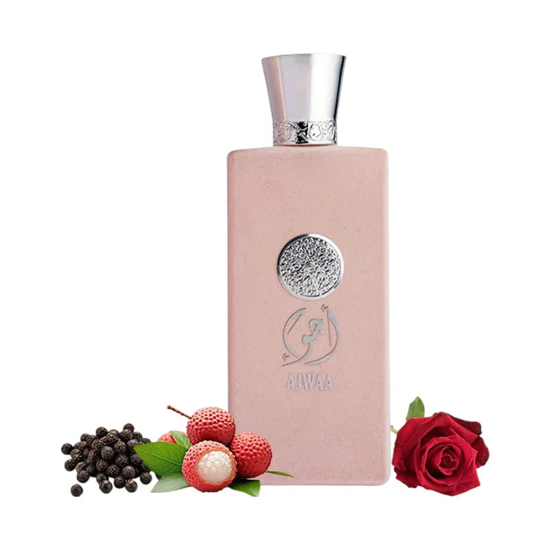 Flacon de parfum rose Ajwaa entouré de litchis, poivre noir et une rose rouge.