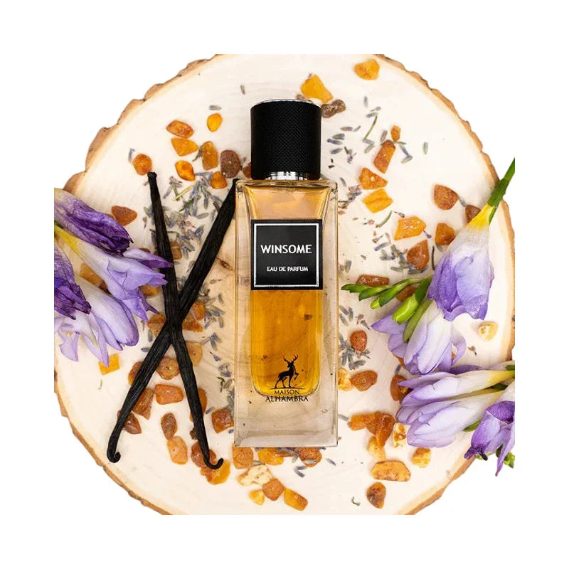 Eau de parfum Winsome de Maison Alhambra sur un socle en bois avec fleurs et vanille